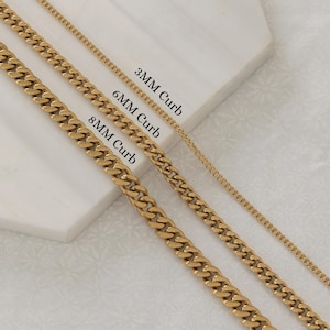May include: Gold-colored curb chain necklaces in 3mm, 6mm, and 8mm widths. The chains are displayed on a white surface. Text labels identify each chain size. The chains are a shiny gold color.