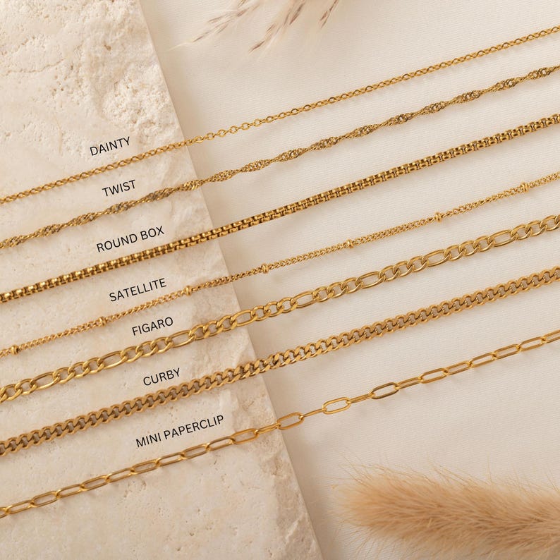 May include: A close-up of nine gold chains of different styles, including dainty, twist, round box, satellite, figaro, curby, and mini paperclip. Each chain is labeled with its name.