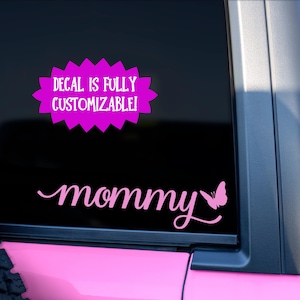 May include: Pink car window decal with the text "mommy" in a cursive font with a butterfly to the right of the word. A pink banner above the decal reads "Decal is fully customizable!"