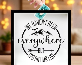May include: A black shadow box with the text "WE HAVEN'T BEEN everywhere BUT IT'S ON OUR LIST". A hand is placing a postage stamp into the box. The stamp has a floral design and the text "MISSISSIPPI".