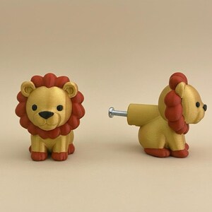 Pu&ograve; includere: Due pomelli per armadi a forma di leone. I pomelli sono dorati con criniere e zampe rosse. Un pomello &egrave; in posizione verticale, l'altro &egrave; di lato, mostrando l'attacco a vite. Questi pomelli decorativi sono adatti per mobili per bambini.