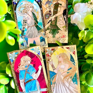 Peut inclure: Quatre épingles en émail de couleur or représentant des illustrations de personnages de la série de jeux vidéo The Legend of Zelda. Les épingles sont rectangulaires et ont une bordure dorée. Les personnages sont représentés dans un style anime stylisé. Les épingles sont parfaites pour les fans de la série The Legend of Zelda.