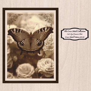 May include: A sepia-toned cross stitch pattern featuring a butterfly with brown and black wings, surrounded by roses. The pattern is titled "Cat's Eye Treasure Chest" and is part of "The Cross Stitch Collection".