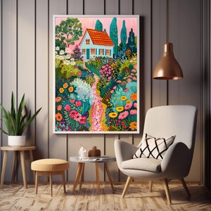 May include: A framed art print showing a garden path leading to a house with a red roof and blue walls. The artwork features vibrant flowers, trees, and a pink sky, creating a whimsical scene. The print is displayed in a modern living room setting.