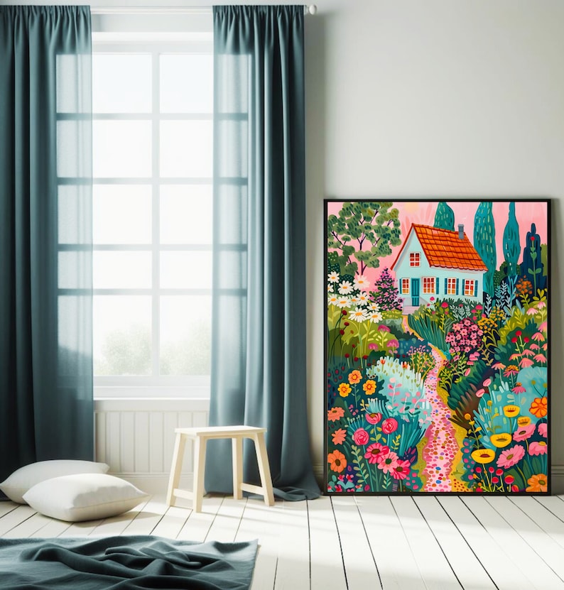 May include: A framed art print showcasing a vibrant garden scene with a small house. The house features a red tiled roof and blue walls, surrounded by colorful flowers and lush greenery. The artwork is set against a pink sky, creating a cheerful atmosphere.
