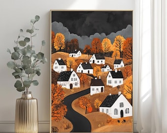 May include: A framed wall art print depicting a landscape with white houses featuring dark roofs, nestled among orange and yellow autumn trees. A winding black road leads through the hilly terrain under a dark, cloudy sky. The art is displayed in a room.