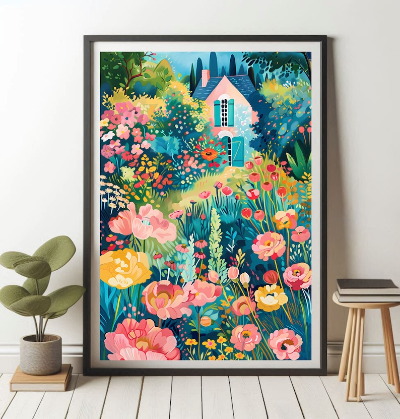 May include: A framed art print featuring a colorful illustration of a cottage surrounded by a vibrant garden. The artwork showcases a pink house with blue shutters, nestled among lush flowers in shades of pink, yellow, and red, set against a backdrop of green foliage.