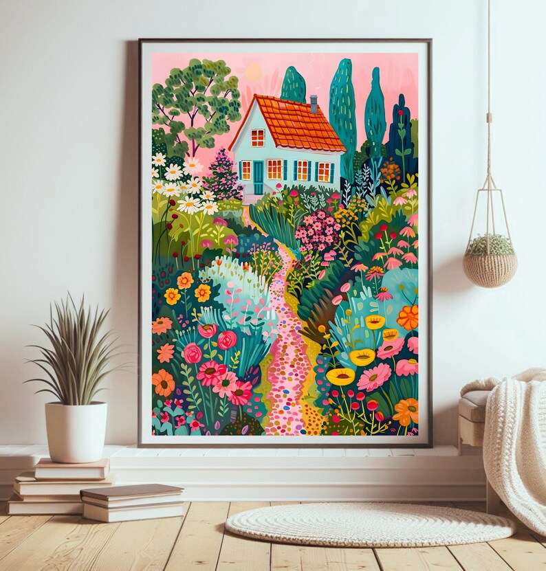 May include: A framed art print showing a vibrant garden scene with a light blue house, orange roof, and a winding path. The garden is filled with flowers in pink, yellow, and green. The artwork is displayed on a white wall.