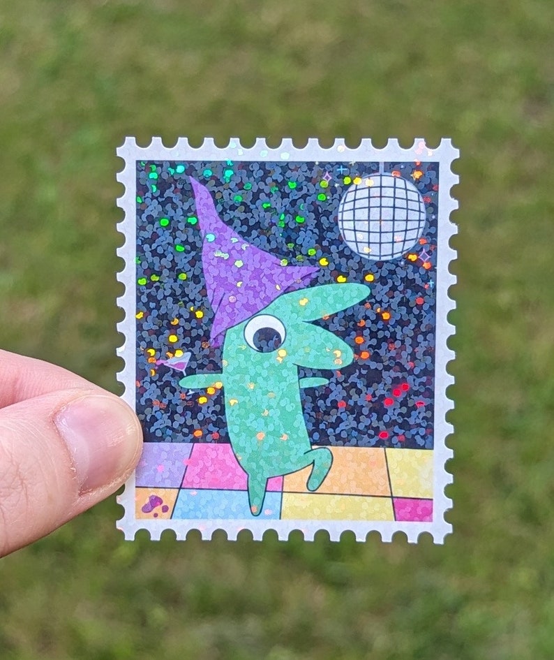 May include: A green creature wearing a purple hat dances on a glittery black background with a disco ball. The creature is holding a martini glass. The image is printed on a white sticker with a postage stamp border.