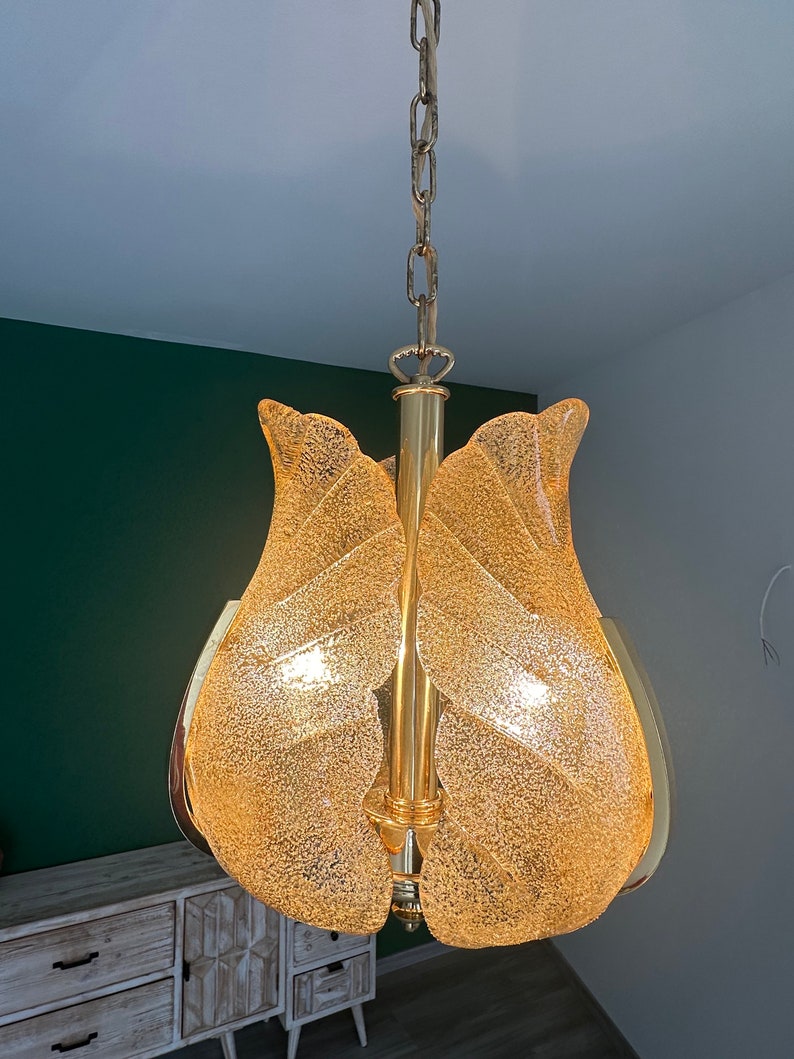 May include: A gold-toned chandelier with a chain and a frosted glass shade shaped like a tulip.