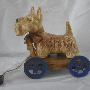 Ceramic Scottie Dog mounted on a plinth and wheels 1930s