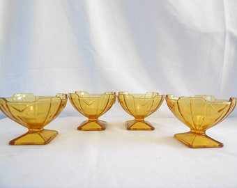 May include: Set of four amber glass dessert dishes with a fluted design and square bases.