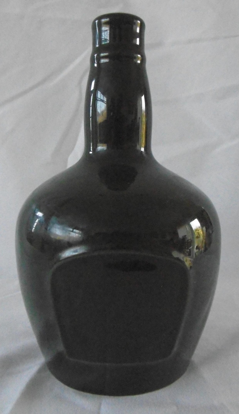 May include: A black ceramic bottle with a rounded body and a narrow neck. The bottle has a smooth, glossy finish and a rectangular label area.