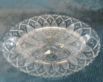 May include: A clear glass serving dish with three sections, featuring a starburst pattern.