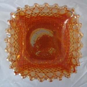 Puede incluir: Un plato cuadrado de vidrio ámbar con un patrón de diamante y un borde festoneado.