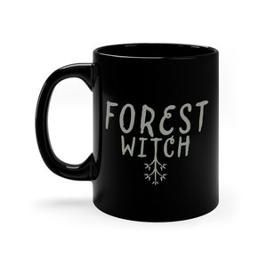 May include: Black ceramic mug with a white design that says "FOREST WITCH" with a stylized tree branch underneath.