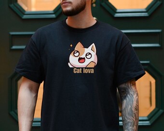 Op de afbeelding: Zwart T-shirt met een cartoonkat die een witte en oranje hoed draagt. De kat glimlacht en heeft grote ogen. De tekst "Cat lova" is onder de kat gedrukt.