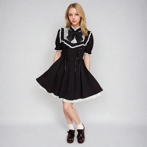 view of a girl wearing a black jirai kei dress with lace ruffles and black bow, j-fashion, japanese fashion, harajuku fashion, ryousangata, girly kei, dark girly, lolita fashion, sweet lolita, himekaji, pastel goth, cutecore, kfashion