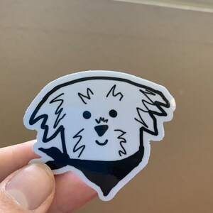 May include: A black and white line drawing of a dog wearing a bandana. The dog has a fluffy, curly coat and a happy expression.