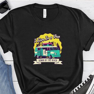 May include: Black t-shirt with a graphic of a teal van with the text "I Live In a Van Down By The River".
