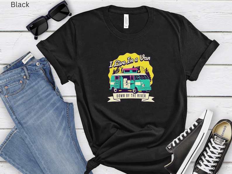 May include: Black t-shirt with a graphic of a teal van with the text "I Live In a Van Down By The River".