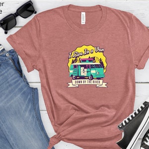 May include: A heather mauve t-shirt with a graphic of a teal van with the text "I Live In A Van Down By The River".
