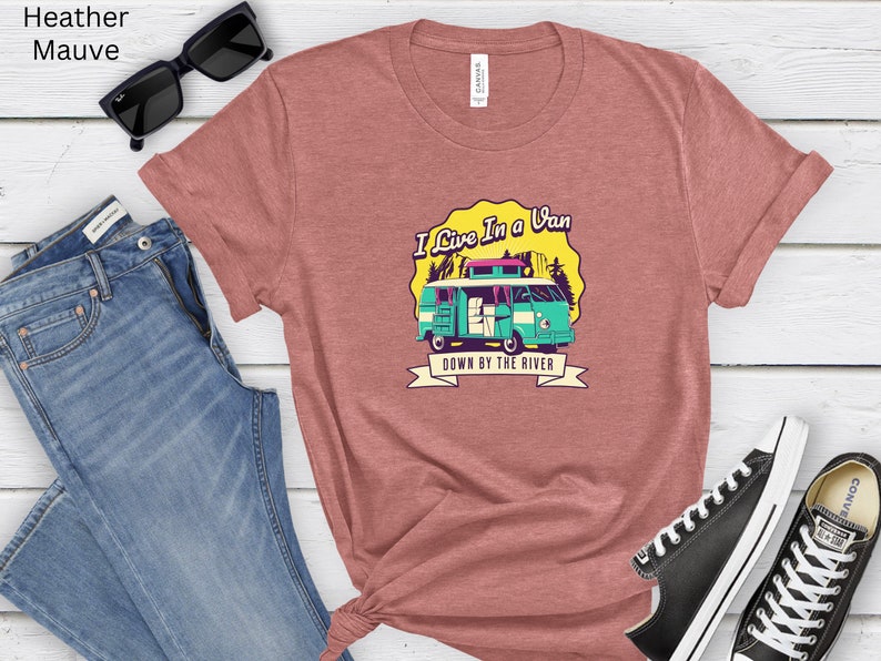 May include: A heather mauve t-shirt with a graphic of a teal van with the text "I Live In A Van Down By The River".