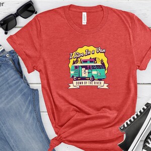 May include: Red heather t-shirt with a graphic of a vintage van with the text "I Live In A Van Down By The River".