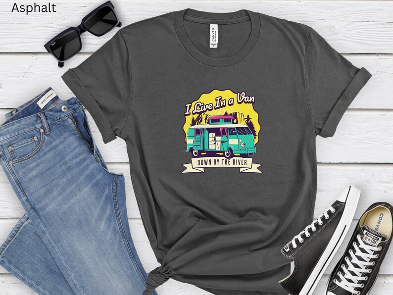 May include: A dark gray t-shirt with a graphic of a teal blue van with the text "I Live In A Van Down By The River".