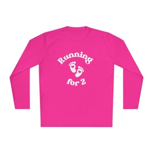 Pode incluir: Camiseta rosa de manga comprida com texto branco que diz "Running for 2" e um gráfico de duas pegadas com corações.