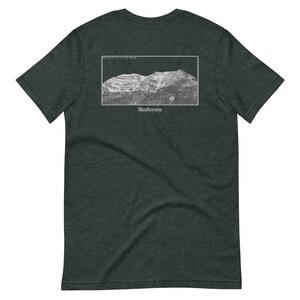 Puede incluir: Una camiseta verde oscuro con un gráfico blanco de una cordillera y el texto "Montmorinne".