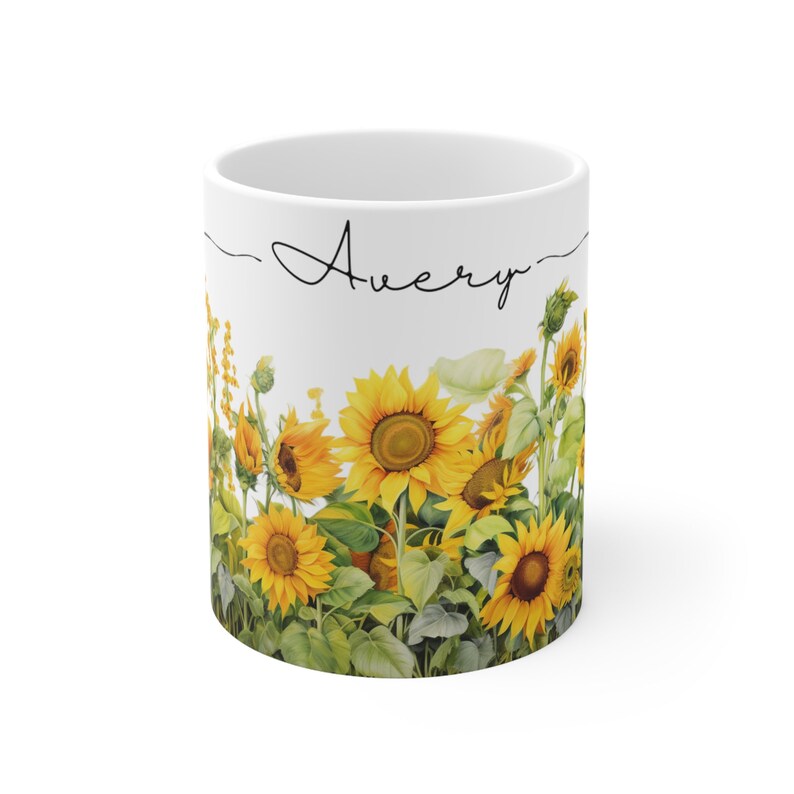 May include: White ceramic mug with a sunflower design and the name "Avery" written in black cursive on the front.