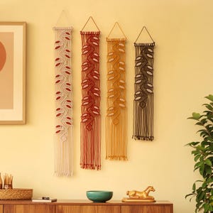 Tapiz de macramé estilo bohemio para pared, tapiz de hojas y enredaderas, tonos tierra de atardecer desértico.