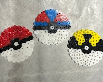 May include: Three Poke Balls made with white, red, blue, black, and yellow perler beads.