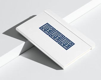 May include: A white notebook with a blue geometric design on the cover. The design is a stylized Arabic script.