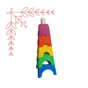 Può includere: Un set di sgabelli a gradini in plastica colorati con colori arcobaleno, tra cui rosso, arancione, giallo, verde e blu. Gli sgabelli sono impilati uno sopra l'altro, creando una torre.
