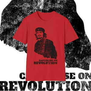May include: Red t-shirt featuring a black and white image of a man wearing a military cap and the text "Capitalise on Revolution".