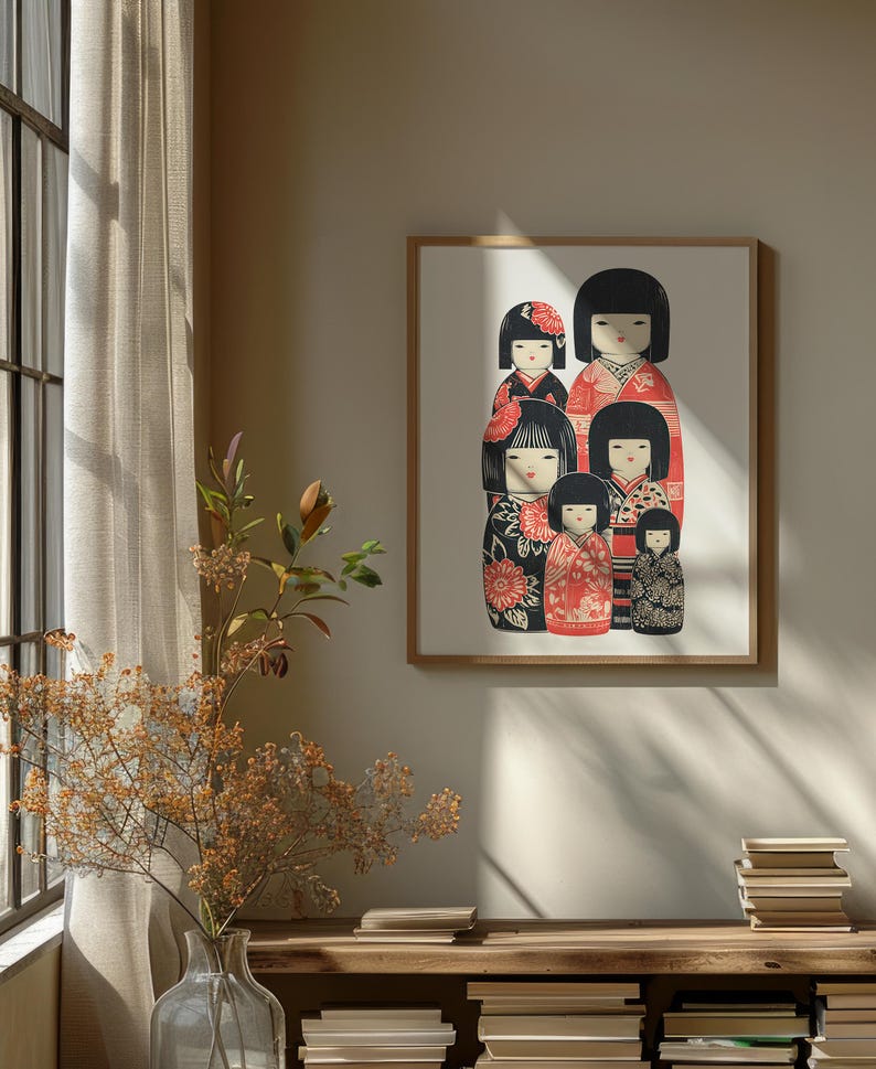 Puede incluir: Una impresi&oacute;n enmarcada que presenta un grupo de mu&ntilde;ecas Kokeshi japonesas estilizadas. Las mu&ntilde;ecas tienen cabello negro y visten kimonos estampados en rojo, negro y blanco. La obra de arte se exhibe en una pared sobre una estanter&iacute;a de madera con libros y un jarr&oacute;n con flores secas.