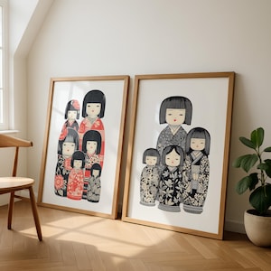 Puede incluir: Dos impresiones enmarcadas con mu&ntilde;ecas Kokeshi japonesas. Las mu&ntilde;ecas tienen cabello negro y visten kimonos estampados en rojo, negro y blanco. Los marcos son de madera clara y las impresiones se exhiben contra una pared blanca.