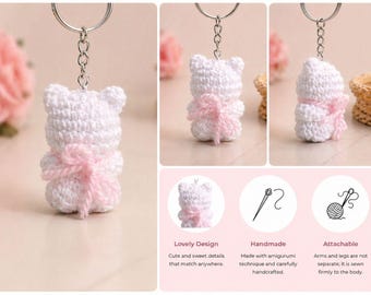 May include: A white crochet bear keychain with a pink bow. The bear has a silver keychain ring attached to its head. The image also includes text that says "Lovely Design", "Handmade", and "Attachable".