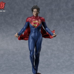 May include: A blue and red superhero figurine with a flowing red cape, standing on a rocky base. The figurine has a determined expression and is posed with arms outstretched.