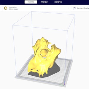 May include: A 3D model of a yellow skull-like object is shown in a 3D printing software program. The software is called Ultimaker Cura. The model is being prepared for printing. The software shows the model in a 3D space with a grid background.