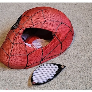May include: Red and black Spider-Man mask with a white mesh eye piece. The mask is made of fabric and has a web design.