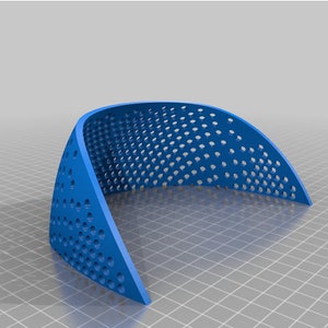 May include: A blue plastic curved object with a honeycomb pattern of holes. The object is designed to be used as a support for a plant or other object.
