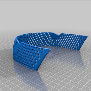May include: A blue plastic 3D printed object with a grid pattern. The object is curved and has a rounded shape.