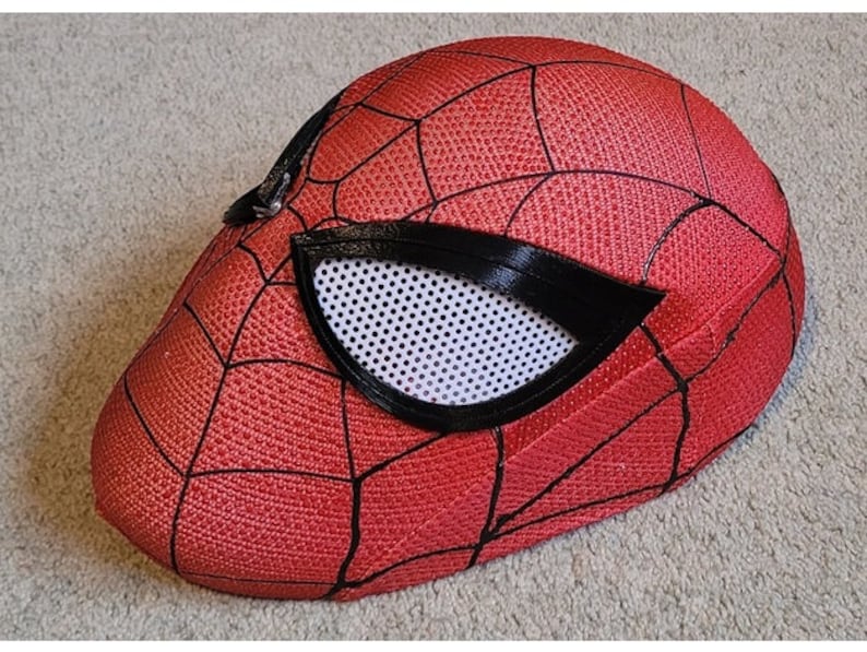 May include: A red and black Spider-Man mask with a mesh eye opening. The mask is made of a textured fabric and has a 3D design.