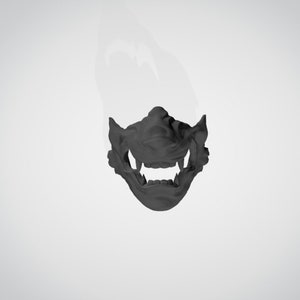May include: A black plastic mask with a detailed design of a snarling face. The mask covers the lower half of the face and has a prominent set of teeth.