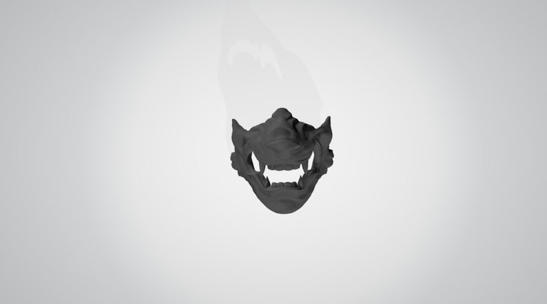 May include: A black plastic mask with a detailed design of a snarling face. The mask covers the lower half of the face and has a prominent set of teeth.