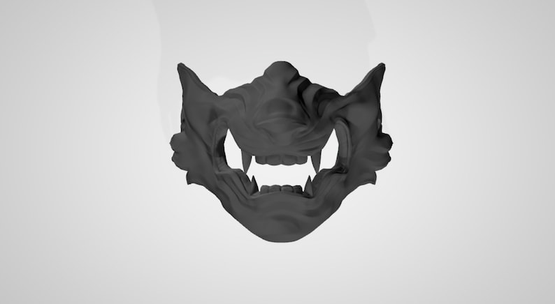 May include: A black plastic mask with a detailed design resembling a snarling animal face. The mask has sharp teeth and a textured surface.