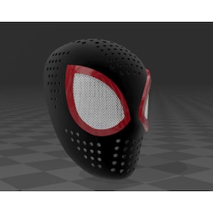 Op de afbeelding: Zwart masker met rode accenten rond de oogopeningen. De oogopeningen zijn wit met een gaaspatroon. Het masker heeft kleine gaatjes over het oppervlak. Zijaanzicht van het masker.